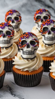 cupcakes decorated with sugar skulls and sprinkles on a marble surface