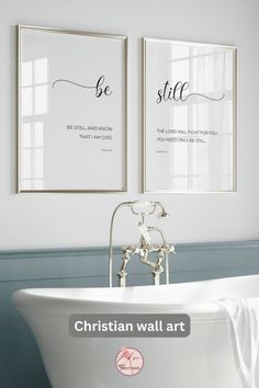 two framed pictures above a white bathtub in a bathroom with the words, be still and know that i am god