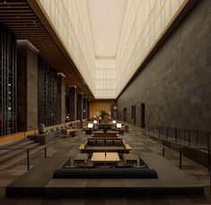 an empty lobby with tables and couches in it