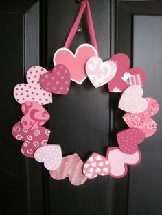 a wreath made out of paper hearts on the front door for valentine's day