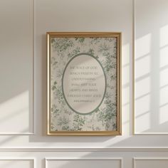 a frame hanging on the wall above a fireplace in a room with white paneling