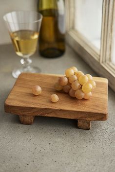 grapes on a cutting board next to a glass of wine