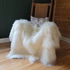 a chair that is sitting in the middle of a room with a fluffy blanket on top of it