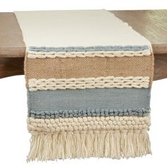 a wooden table with a white and blue blanket on it's end, next to a wood bench