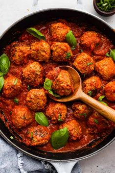 meatballs and sauce in a pan with a wooden spoon on the side, ready to be eaten