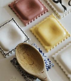 a wooden spoon sitting on top of a white table next to different colored plates and stampers