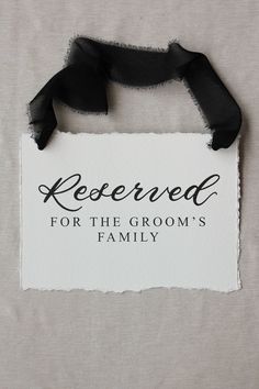 a sign that says reserved for the groom's family hanging on a white wall