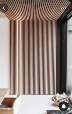 a white table and chair in front of a wooden wall with vertical stripes on it