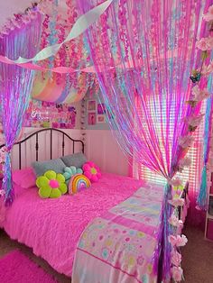 a bedroom with pink and purple decor on the walls, bed canopy over it, and pillows