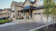 a large house with two garages in the front and one car parked on the driveway