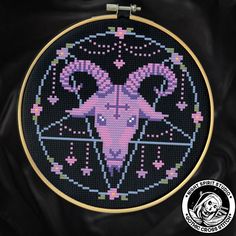 a cross - stitch pattern with an image of a ram in the center, on a black background