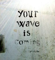 graffiti written on the side of a building that says, your wave is coming up