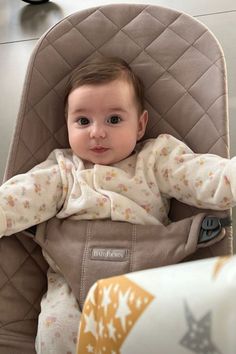 a baby sitting in a highchair with its head resting on the armrest