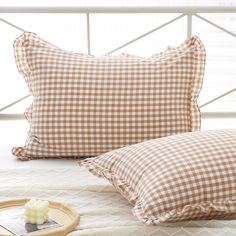 two pillows sitting on top of a bed next to a tray