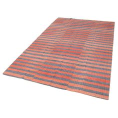 an orange and grey striped rug on a white background with clippings to the side