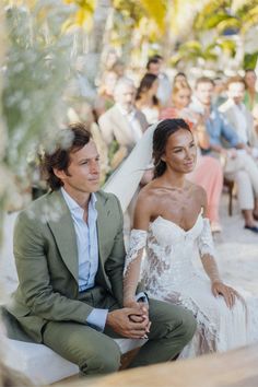 a man and woman sitting next to each other in front of a group of people