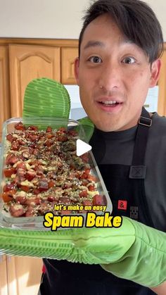 a man holding up a dish full of spam bake