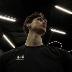 a young man is looking up at the ceiling with his head tilted to the side