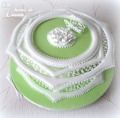 there is a green cake with white decorations on it