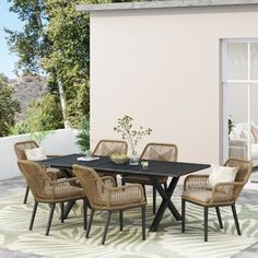 an outdoor dining table with chairs around it