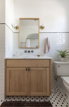 a bathroom with a sink, toilet and mirror in it's centerpieces