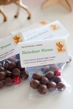 three bags of reindeer noses candy sitting on top of a table next to a toy deer