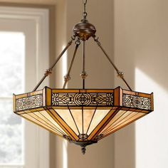 a stained glass chandelier hanging from a ceiling fixture in a room with windows