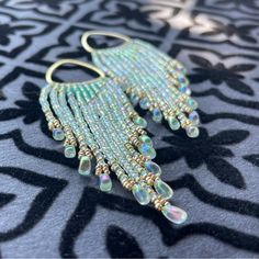 Artisan Boho Beaded Fringe Earrings Gold Lustered, Translucent Sea Glass Green With Subtle Aurora Borealis, Rainbow Effect Accented With Central, Milky Aqua Opal Triangle & Champagne Duracoat Miyuki Beads. Cascading Fringe Strands Ending In Sea Foam Lined, Crystal Drop Beads In Matching Ab Finish. Raw Brass Component Hardware. Choose Your Own Finishings/Clasp: Brass, 28k Gold Plate, Or 18k Gold Fill French Earwire, Closed, Or Open Ear Hook Brand New, One Of A Kind Precision Cut, High Color Resol Over The Ear Earrings, Aqua Beaded Earrings, Bohemian Embellished Beaded Earrings, Grunge Beaded Earrings, Unique Adjustable Beaded Fringe Earrings, Forget Me Not Beaded Earrings, Bohemian Green Beaded Fringe Chandelier Earrings, Artisan Beaded Fringe Earrings For Beach, Cascading Earrings