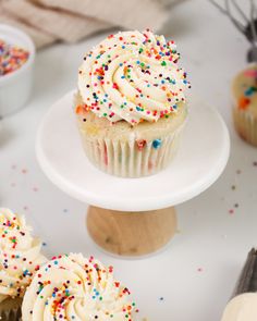 cupcakes with white frosting and colorful sprinkles