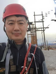 a man wearing a red helmet standing in the street