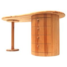 a wooden desk with drawers on it and a round base in the middle, against a white background