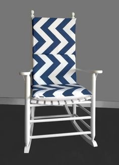 a white rocking chair with a blue and white chevron pattern on the armrests