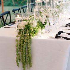 the table is set with white flowers and candles