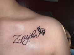 a man with a tattoo on his chest that reads zayden and has footprints in it