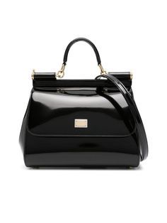 Colour: Black Composition: Exterior: 100% patent leather Designer Colour: Blacks and greys Year: 2024 Made in: Italy Style ID: BB6002A103780999 Measurements: Width: 27cm x Height: 20cm x Depth: 10cm Shoulder strap length: 60cm Handle drop: 8cm Elevate your daily ensemble with a touch of luxury from Dolce & Gabbana's medium Sicily leather tote bag. Flaunting a sleek patent finish and a classic foldover top with magnetic fastening, this exquisite piece is adorned with a striking gold-tone logo plaque. Functional as much as it is fashionable, it comes with metal feet to protect the base, an elegant rolled top handle, and an adjustable detachable shoulder strap for versatility. Its roomy main compartment and convenient internal card slots are lined with a signature leopard print, ensuring both Sicily Bag, Dolce And Gabbana Handbags, Black Leather Crossbody Bag, Large Handbags, Dolce E Gabbana, Black Shoulder Bag, Boutique Online, Black Tote, Mua Sắm