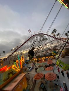 an amusement park at dusk with people on the rides