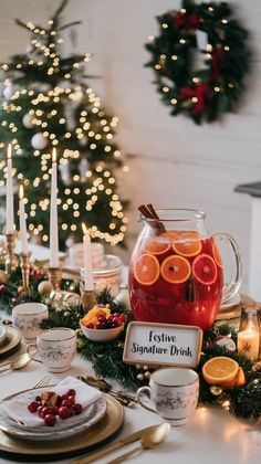 a festive table setting with orange slices, cranberries and tea in front of a christmas tree