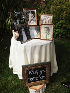 a table topped with pictures and framed photos next to a sign that says wish you