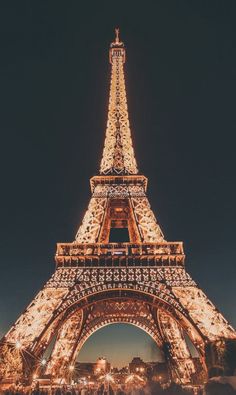 the eiffel tower lit up at night with lights on it's sides