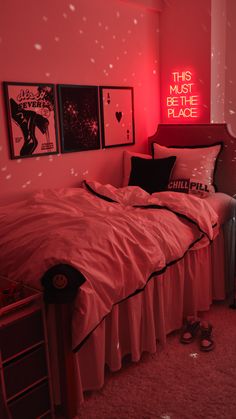 a bedroom with pink walls and pictures on the wall