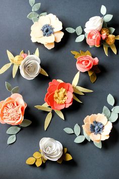 paper flowers are arranged on a black surface