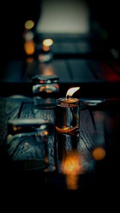 a candle is lit in a glass on a table