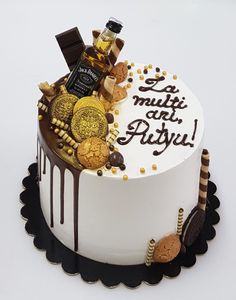 a birthday cake decorated with cookies, chocolates and other treats on a white surface