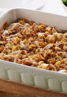 a casserole dish with meat and vegetables in it on a table next to a plate