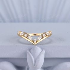 a yellow gold ring with three diamonds on the front and side, sitting on top of a white cloth