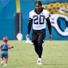 a young boy is running with a toy in his hand while wearing a football uniform