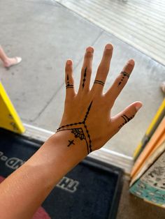 a person's hand with some tattoos on it