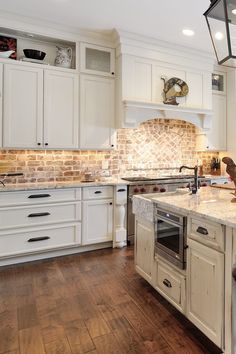 a large kitchen with white cabinets and wood flooring is pictured in this image from the front view