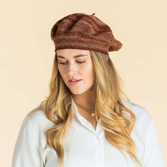 a woman wearing a brown hat and white shirt