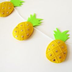 three pineapples are hanging on a string